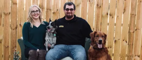 A woman with her partner and two dogs.